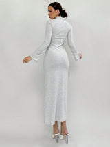 Woman wearing a long, light gray dress against a white background