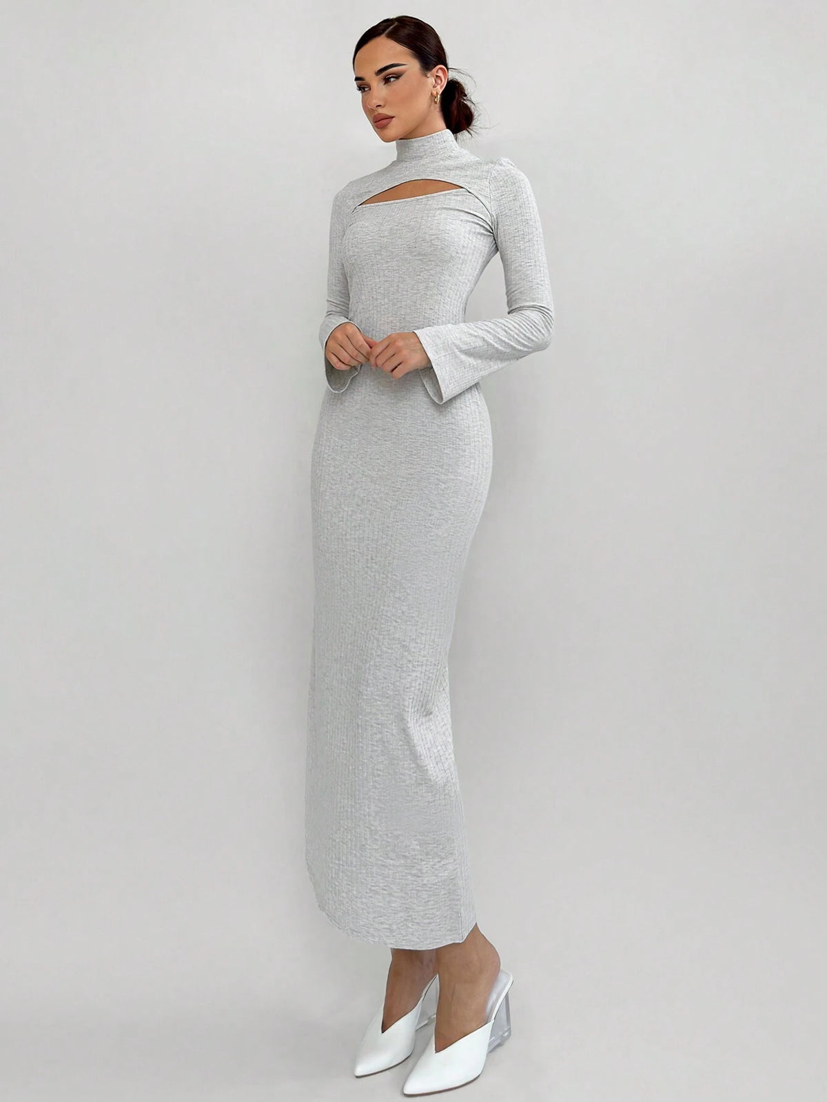 Woman wearing a gray long-sleeve dress with cut-out design on a white background
