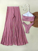 Pink patterned pants and matching bikini set on a beige background
