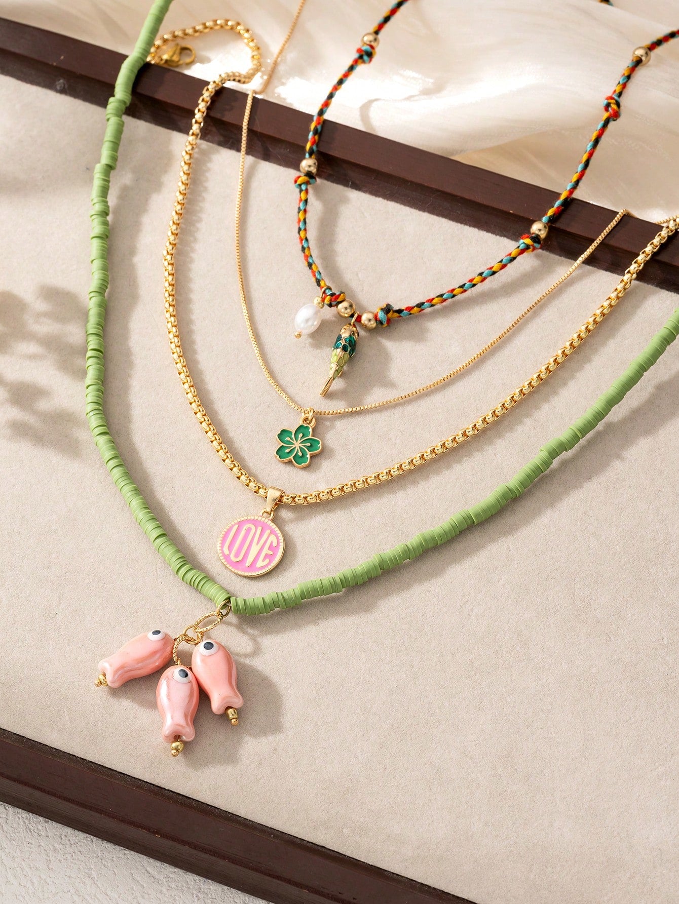 Necklaces with various charms on a neutral background