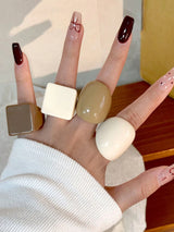 Hand wearing multiple rings with a blurred background