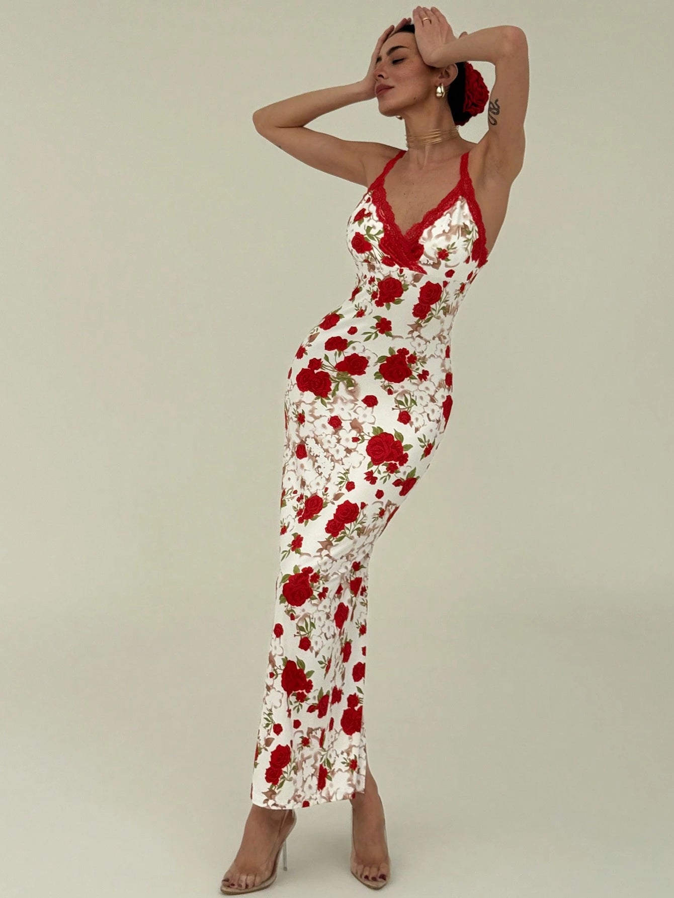 Woman wearing a red and white floral dress against a plain background