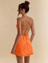 Woman wearing an orange dress with a beige background