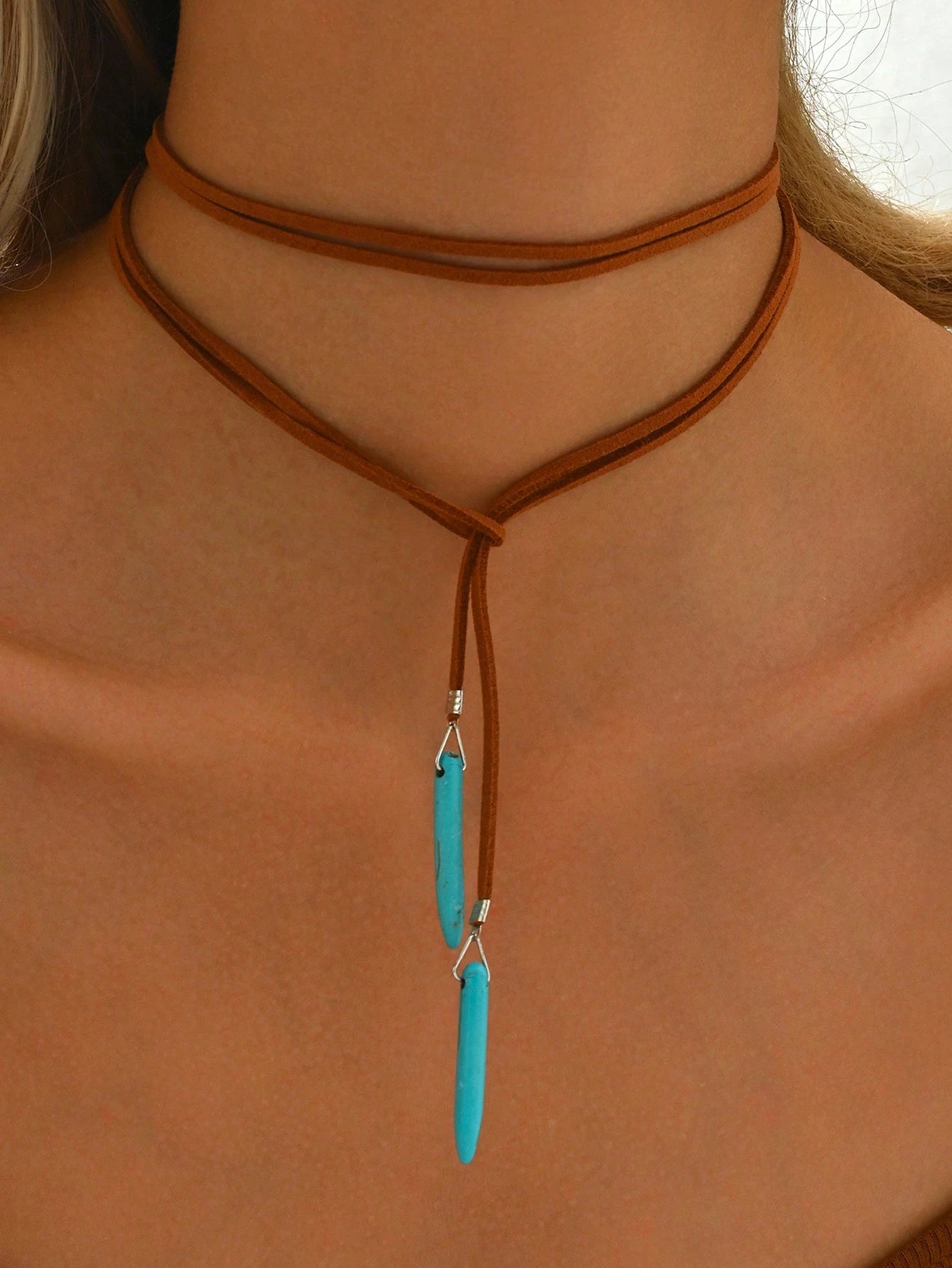 Necklace with turquoise pendant on a person's neck