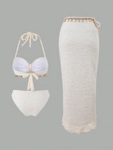 White lace bikini set with matching skirt on a gray background
