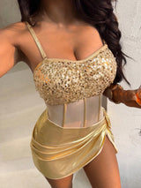 Gold sequin top and skirt worn by a person against a neutral background