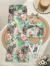 Floral and leopard print bikini set with matching hat on a textured surface.