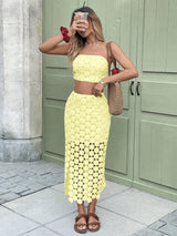 Woman wearing a yellow lace dress standing in front of a green door.