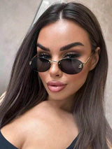 Woman wearing black sunglasses with a neutral background