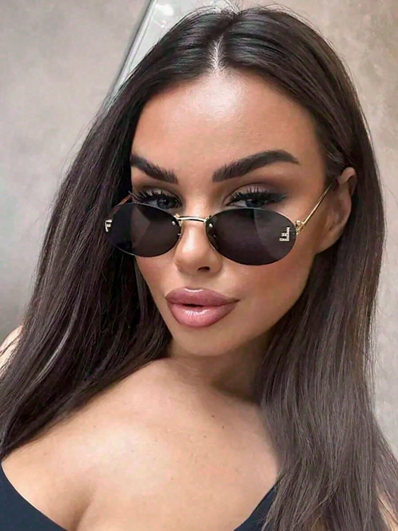 Woman wearing black sunglasses with a neutral background