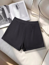 Black shorts on a white surface with a magazine in the background