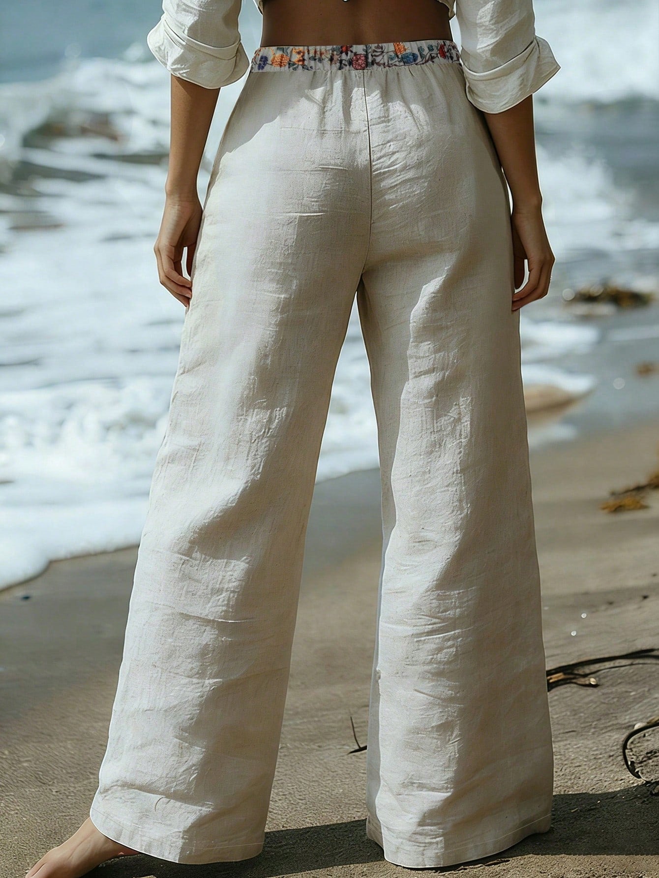 Person wearing white linen pants on a beach