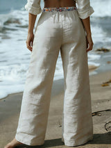 Person wearing white linen pants on a beach