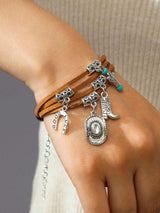 Bracelet with charms on a wrist against a neutral background