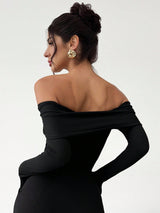Woman wearing a black off-shoulder dress with a plain background
