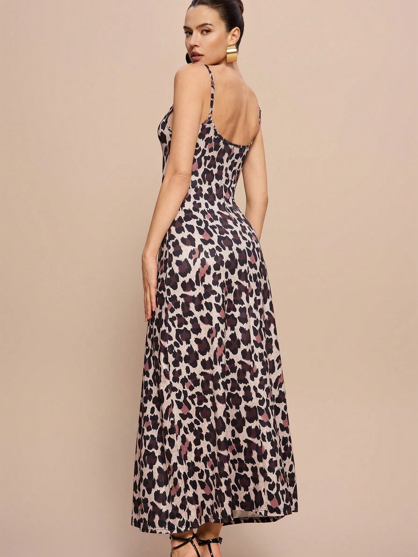 Woman wearing a leopard print dress on a beige background
