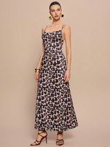 Woman wearing a leopard print dress against a beige background
