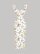White dress with black polka dots and colorful floral pattern on a gray background