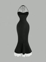 Black dress with ruffled hem on a gray background