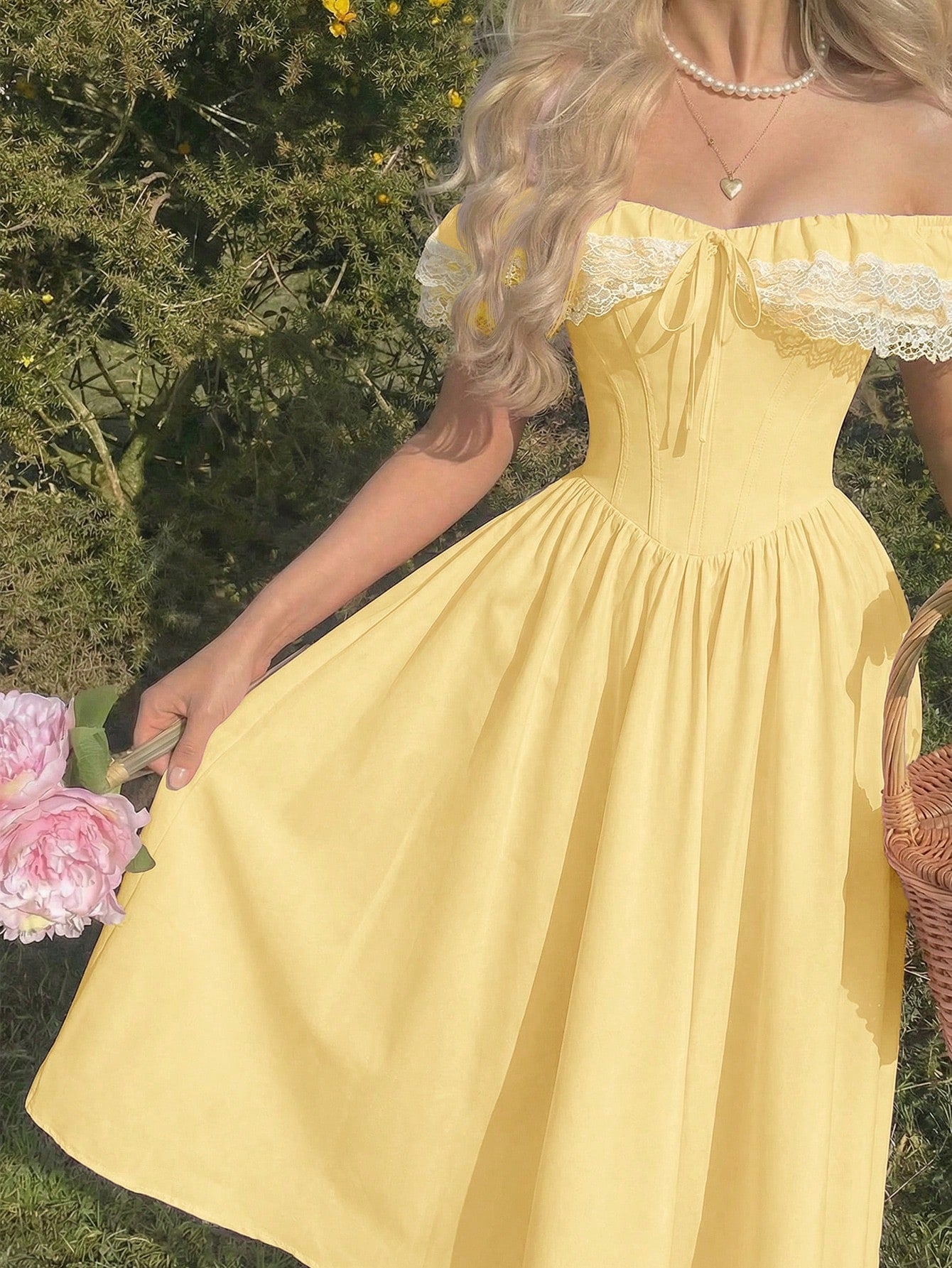 Woman in a yellow off-shoulder dress holding flowers outdoors.