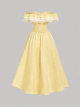 Yellow off-shoulder dress with lace details on a gray background