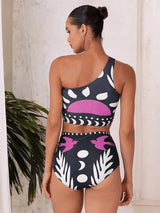 Woman wearing a black and white patterned swimsuit with pink accents.