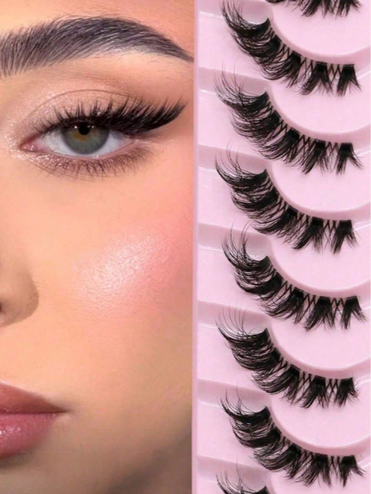 Close-up of a woman's eye wearing dramatic false eyelashes, next to a pink tray holding multiple pairs of black false eyelashes.