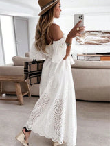 Woman in a white dress taking a selfie in a modern living room.