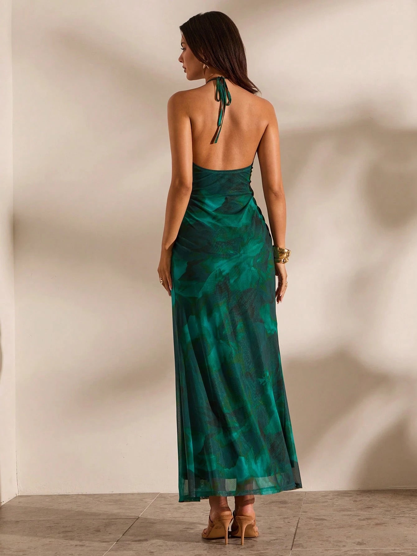 Woman wearing a green dress with a neutral background