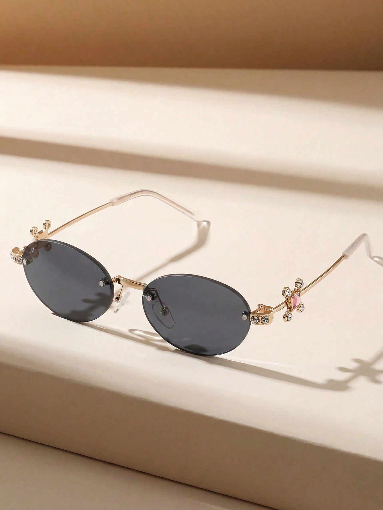 Sunglasses with decorative arms on a beige surface