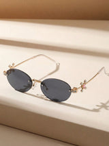 Sunglasses with decorative arms on a beige surface