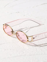 Sunglasses with pink lenses and gold frames on a light background
