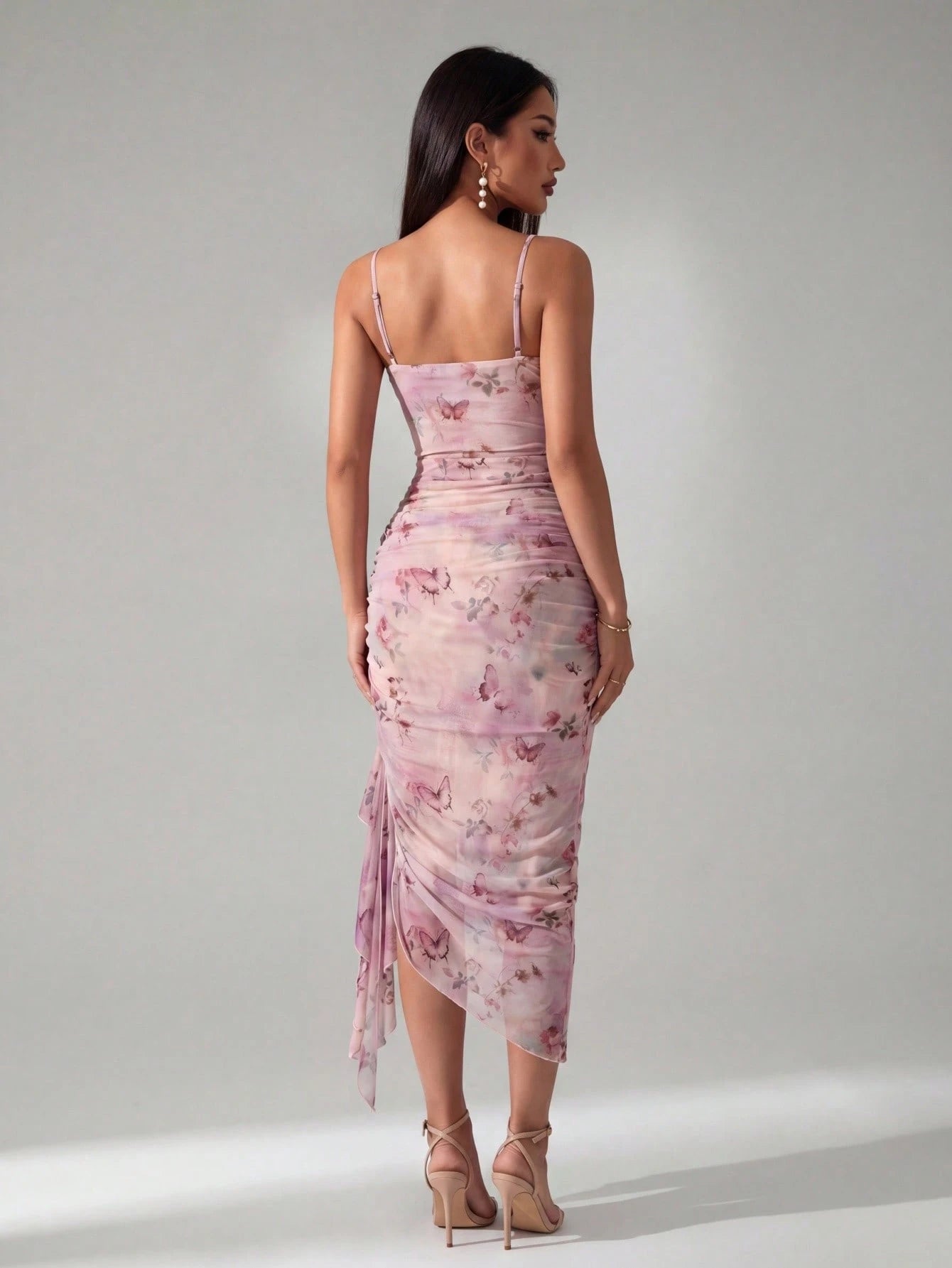 Woman wearing a pink floral dress against a gray background