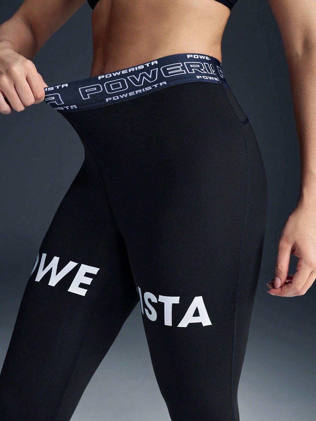 Black leggings with 'Powerista' branding on a dark background