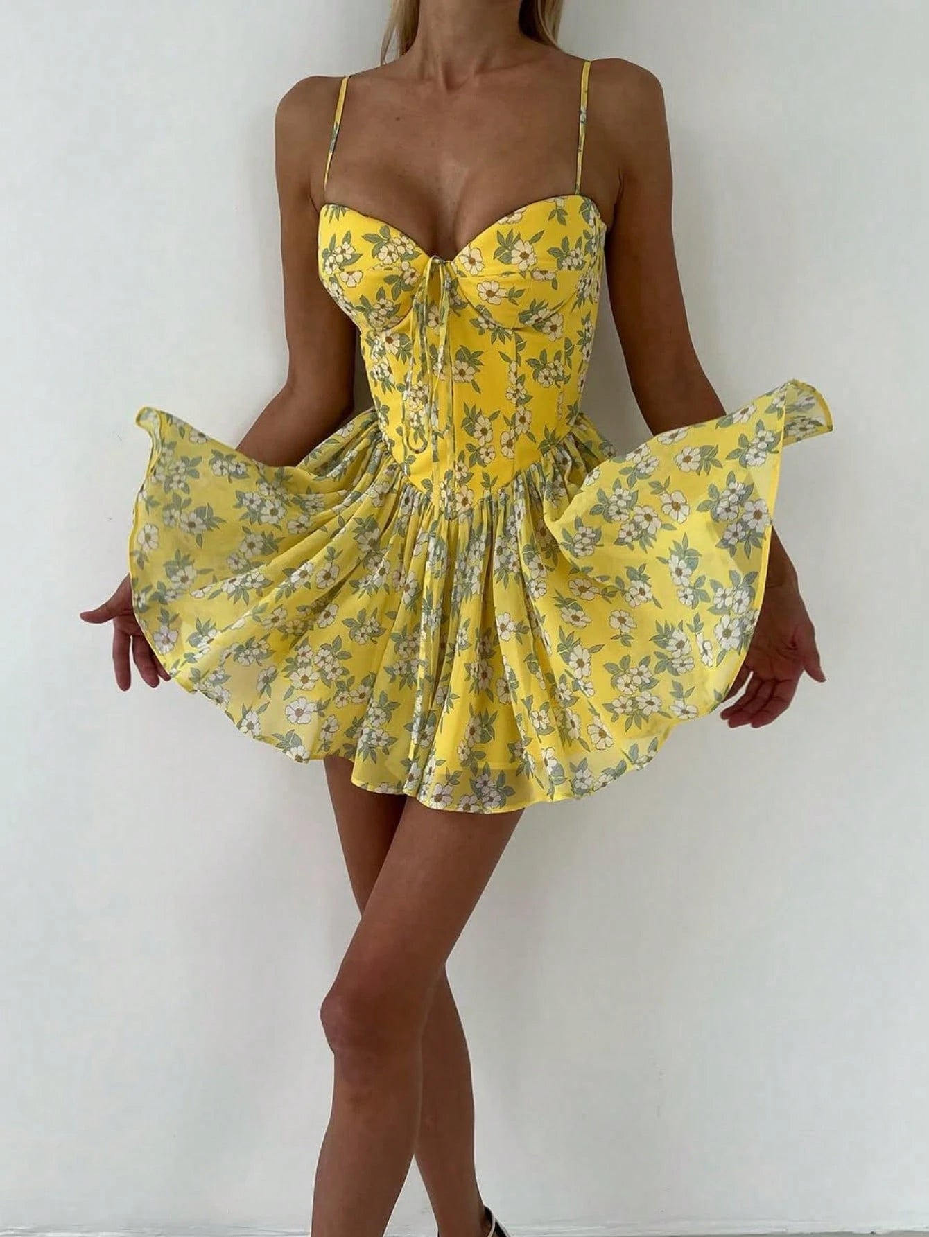 Yellow floral dress being worn against a white background