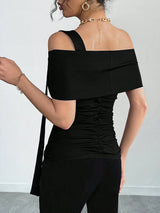 Black off-shoulder top worn by a person on a plain background