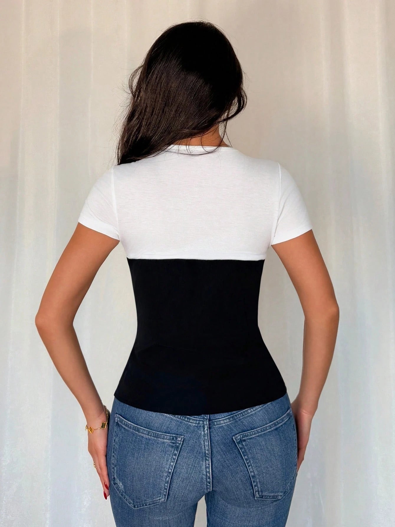 Person wearing a black compression garment over a white shirt with a neutral background
