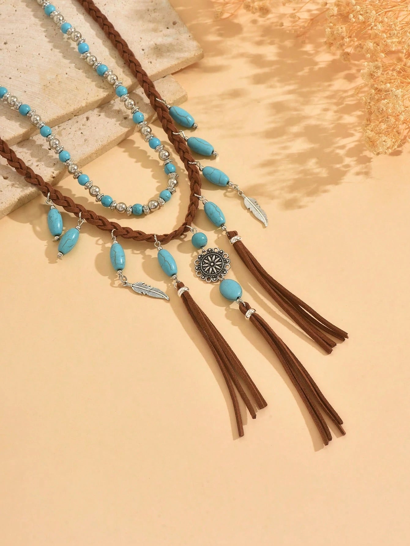 Necklace with turquoise beads and tassels on a beige background