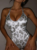 Leopard print swimsuit with sequins worn by a model against a neutral background