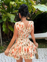 Woman wearing a floral dress in an outdoor setting with greenery.