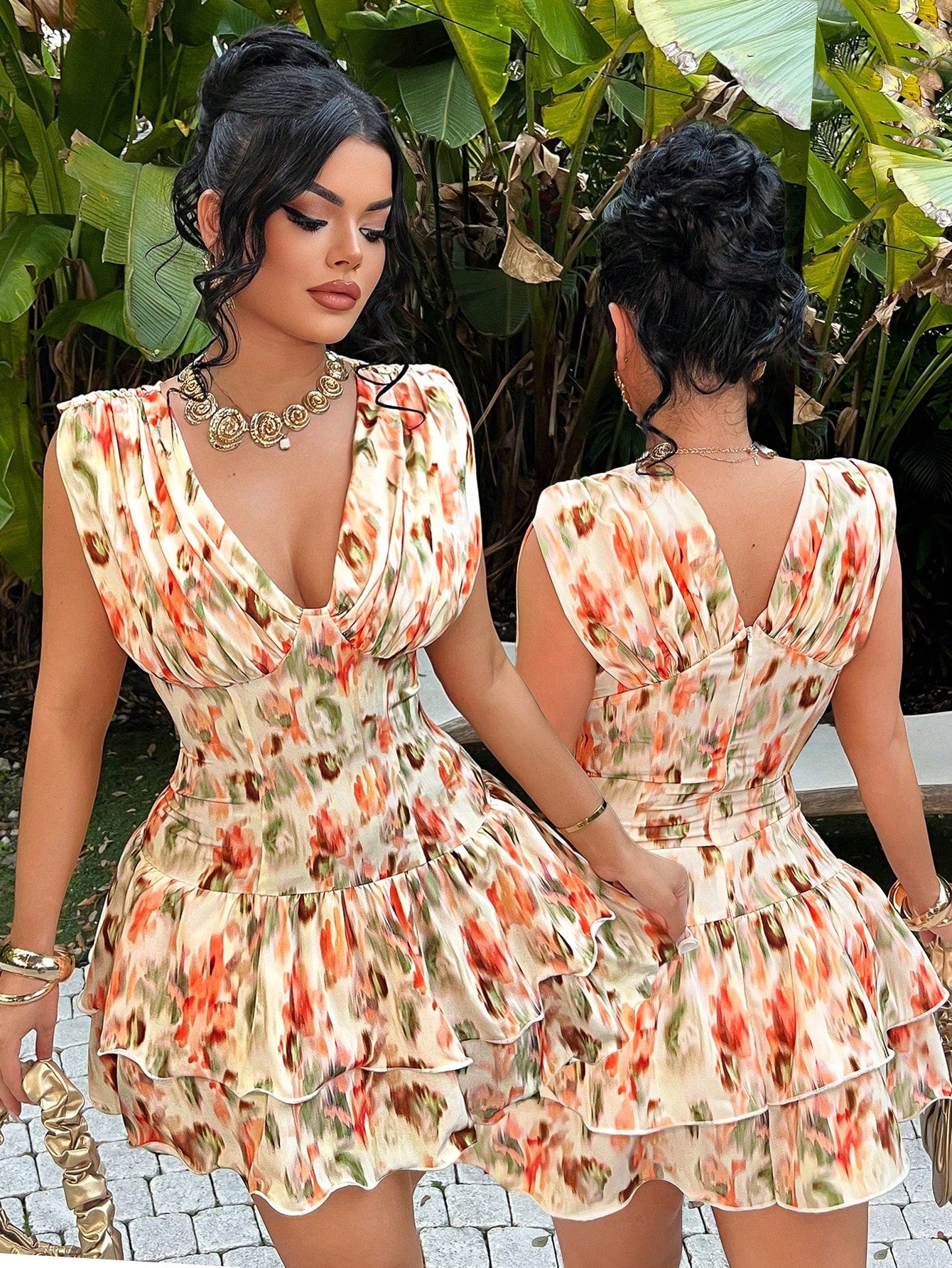 Two women wearing floral dresses standing in front of green foliage.