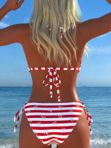 Person wearing a red and white striped bikini with a clear blue sky and ocean background