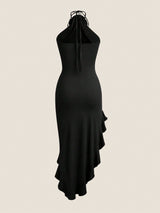 A black halter-neck midi dress with a ruffled asymmetrical hem and tie-front detail, shown against a solid light beige background.