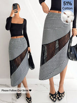 Woman wearing a black and white checkered skirt with sheer panels, holding a phone.