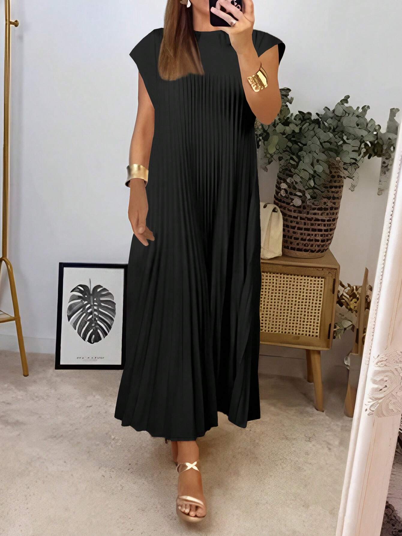 Woman wearing a black dress in a room with decor elements.