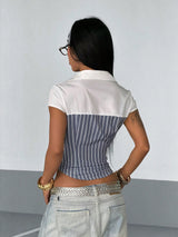 Person wearing a white and blue striped shirt with a plain background