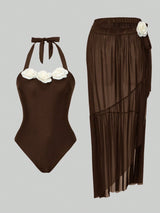 Brown swimsuit with floral details and matching skirt on a gray background