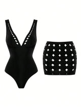 Black swimsuit with cut-out design and black skirt with white diamond pattern on a white background