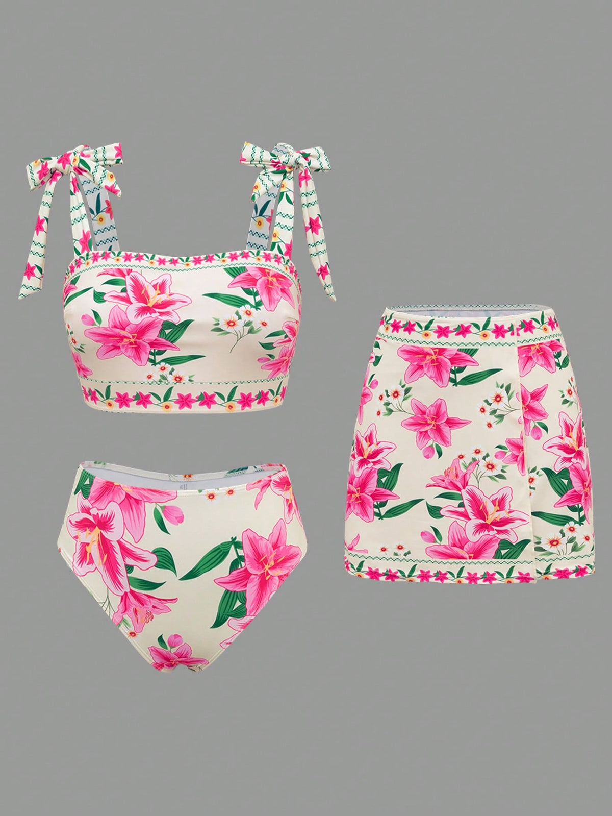 Three-piece bikini set with a pink and green floral print on a cream background, including a tie-shoulder top, high-waisted bottoms, and a matching skirt, displayed on a solid gray background.