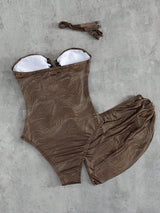 Brown swimsuit with white lining on a gray concrete surface